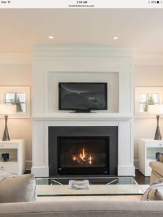 a living room with a fire place and couches in front of the tv screen