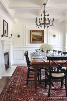 a dining room table with chairs and a chandelier hanging from it's ceiling