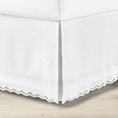 a white bed skirt with scalloped edges