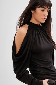 Our Perry Cold Shoulder Top is all about the drape. Crafted in soft Tencel jersey, from a halter collar neckline, long, cold shoulder raglan sleeves create beautiful drapes that cascade down the arms. Perry's a statement top that delivers all the style required for a head-turning look. [SPLIT] Sam is 5'8" (173 cm) tall, wearing size XS. Total length from the center back is approximately 22.5" (57cm). Sleeve length is approximately 25.5" (65 cm). Sustainable European Jersey (96% Tencel, 4% Elasta Black Cold Shoulder Top, Tie Collar, Style Goals, Fashion Designing, Boho Style Jewelry, Sweatshirt Fabric, Cold Shoulder Blouse, Crochet Crop Top, Beautiful Drapes