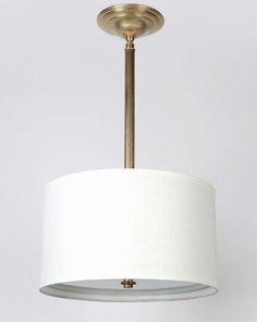 a light fixture with a white shade hanging from the ceiling