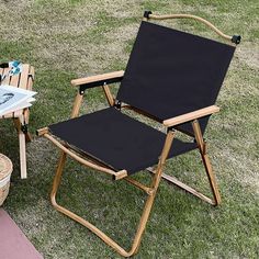 two folding chairs sitting on top of a grass covered field