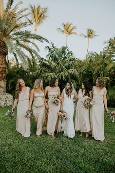 a group of women standing next to each other on top of a lush green field