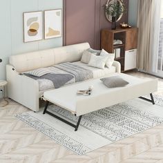 a white couch sitting on top of a hard wood floor next to a coffee table