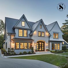 a large white house with lots of windows on the front and side of it's roof