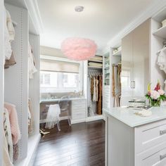 a walk in closet filled with lots of white furniture and drawers next to a window