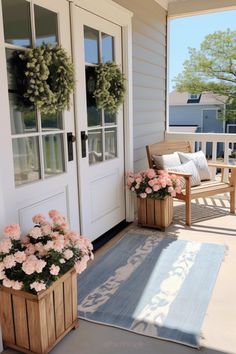 two wooden planters filled with pink flowers sitting on top of a porch next to a door