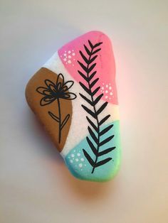 a painted rock with a plant on it