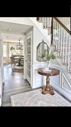 an entry way with a table and stairs in the background, along with a rug on the floor