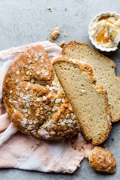 a loaf of bread sitting on top of a towel next to a bowl of butter