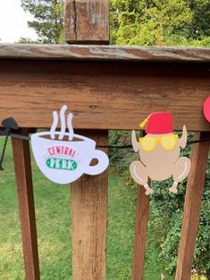 some paper cutouts hanging from a wooden fence