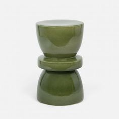 two green vases sitting on top of each other in front of a white background