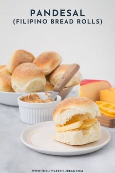 a white plate topped with a sandwich next to bowls of cheese and breadsticks