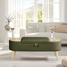 a living room with a white couch and green footstool in front of a window