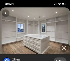 an empty room with white cabinets and wood floors