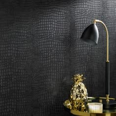 a black and gold wallpaper with a pineapple lamp next to it on a table