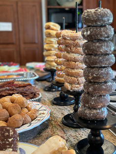 a table topped with lots of donuts and other pastries on top of plates