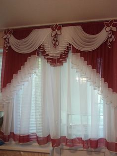 a window with red and white curtains hanging from it's side