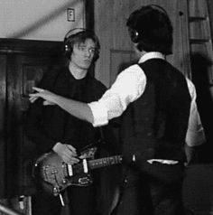 two young men are playing guitars in a recording studio