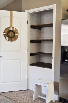 an open pantry door with shelves on both sides and a clock mounted to the wall