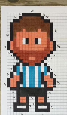 a cross stitch pattern with a man wearing a blue shirt and black pants, standing in front of a wooden table