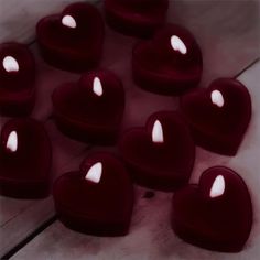 many heart shaped candles sitting on top of each other in the middle of a floor