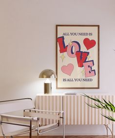 a room with a chair and a painting on the wall above it that says love is all you need