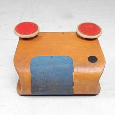 an old wooden toy with red and blue knobs