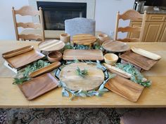 a wooden table topped with lots of different types of plates and bowls on top of it