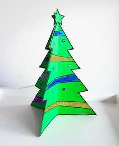 a green paper christmas tree on a white surface