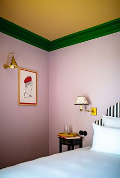 a room with a bed, lamp and pictures on the wall