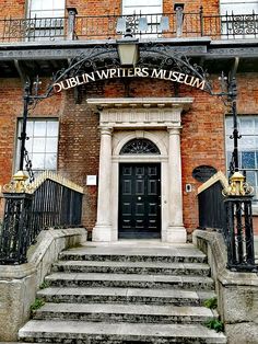 the entrance to dublin writer's museum with steps leading up to it and an iron gate