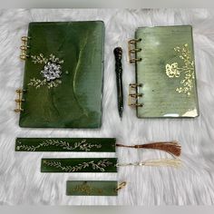 the contents of a green notebook are laid out on a white furnishing area