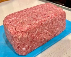 a large piece of meat sitting on top of a blue cutting board