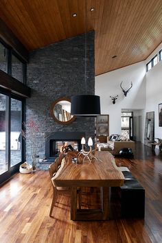 a large wooden table sitting in the middle of a living room next to a fire place