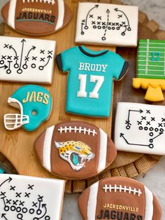 decorated cookies are arranged on a tray with footballs and jersey designs in the shape of shirts