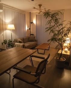 a living room filled with furniture next to a wooden table and chair under a lamp