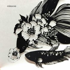 two black and white fish with flowers in their beaks on a paper cutout