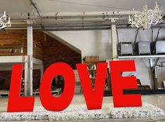 a large red love sign sitting in the middle of a room