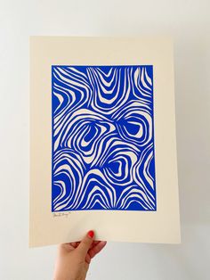 a hand holding up a blue and white print