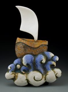 a ceramic sculpture with a sailboat on top of it