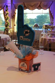 the table is set up for an event with decorations and wine glasses on it, including a bottle opener