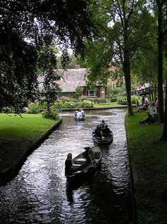 people are riding in small boats down the river