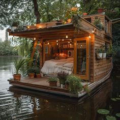 a small house boat floating on top of a body of water with plants growing out of it