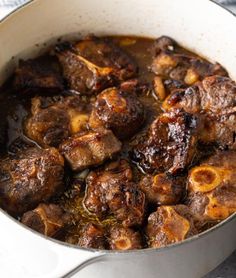 a pot filled with meat and sauce on top of a table