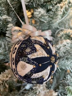 a christmas ornament hanging from a tree with snowflakes and stars on it