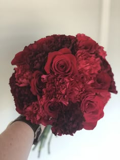 a person holding a bouquet of red flowers