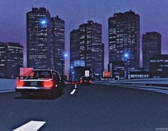 a car is driving down the road in front of some tall buildings at night time