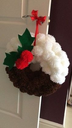 a fake wreath is hanging on the door with red and white pom - poms