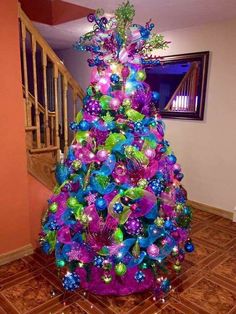 a brightly colored christmas tree in the corner of a room